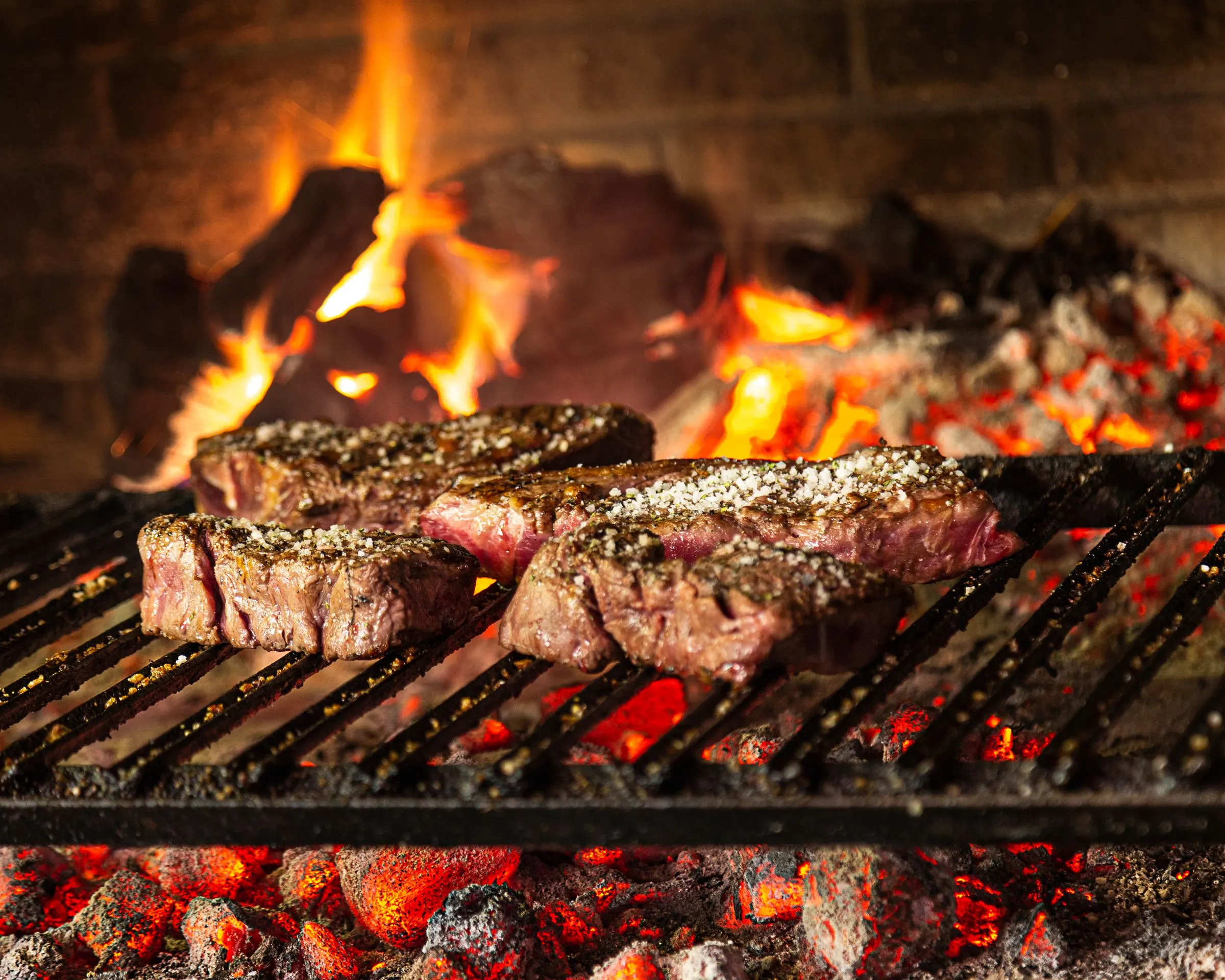 Txuletas de vaca vieja sobre la parrilla de leña, con la brasa al rojo